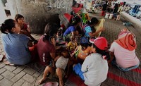 Para ibu dan anak-anak penghuni bangunan liar berkumpul di bawah jembatan layang Jalan Ahmad Yani, Jakarta Timur, sesaat setelah rumah mereka dibongkar.