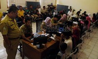 Para petugas dari Dinas Kependudukan Kota Bekasi melayani warga Bekasi yang akan membuat e-KTP, di Kantor Kecamatan Bekasi Selatan, Selasa (07/02).