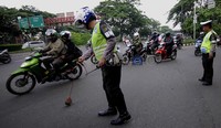 Polisi mencari paku-paku yang bertebaran di jalan dengan menggunakan magnet. Jhoni Hutapea/detikcom.