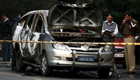 Mobil tersebut hangus terbakar. Reuters/Parivartan Sharma.