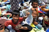 Beberapa anak bermain di tumpukan pakaian bekas yang disumbangkan oleh masyarakat. Fikri Hidayat/detikcom.