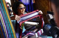 Endhita menunjukan hasil tenunannya yang sudah setengah jadi.