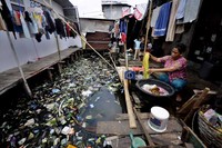 Warga mencuci pakaian di halaman rumahnya di Kampung Bandan, Jakarta Utara.