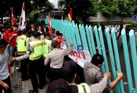 Para pendemo memaksa masuk ke halaman Gedung Kementrian BUMN, Jakarta. Sementara sejumlah polisi berusaha menenangkan mereka.