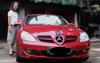 Terpampang sebuah Jaguar hitam dan Mercedes-Benz SLK merah berada di dalam garasinya.