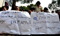 Dalam aksinya mereka membawa poster dan spanduk yang menghujat John Kei