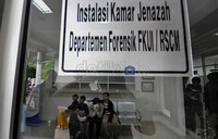Istri Stendly Wenno, Sumiyati beserta anaknya saat menunggu jenazah suaminya di kamar Jenazah RSCM, Jakarta.