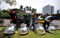 Tiga orang petugas mamasang lampu penerangan jalan di kawasan Monas. Lampu hemat energi diharapkan mampu menekan biaya listrik hingga Rp 8 miliar per bulan.