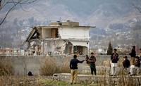 Polisi mengusir warga yang melihat pembongkaran tempat persembunyian Osama bin Laden dari dekat. Reuters/Faisal Mahmood.