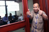 Timas mengacungkan kedua jempolnya sebelum memasuki ruang tunggu terdakwa Pengadilan Tipikor, Jakarta. Ramses/detikcom.