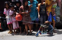 Monyet bernama Sarimin mempertunjukkan kebolehannya memainkan skuter di depan para penontonnya yang masih belia.