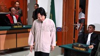 Pepi Fernando memasuki ruangan persidangan dengan kepala tertunduk.