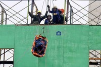 Petugas memperagakan cara mengevakuasi korban kebakaran dari atap gedung.