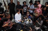 Di depan pintu utama kediamannya Angie menggelar jumpa pers dengan dikawal oleh seorang body guard berpakaian anti peluru.