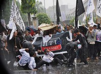 Meskipun diguyur hujan deras, aksi unjuk rasa massa HTI tetap berlanjut.