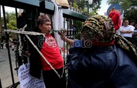 Teatrikal yang dibantu oleh 2 seniman melakukan aksi protes dengan total. Sandal jepit pun digigit untuk menyempurnakan aksi protesnya.