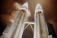 Menara kembar Petronas di Malaysia, terlihat indah di malam hari dengan kemegahan bangunan dan gemerlap lampu yang menghiasi keindahan menara tersebut.