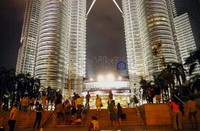 Wisatawan menikmati keindahan Menara Petronas di malam hari.