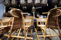 Seorang pedagang membersihkan debu yang menempel di kursi rotan yang dijualnya di kawasan Cikini, Jakarta.