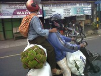 Perjuangan suami istri mencari nafkah walau harus duduk berbagi jok motor dengan karungan buah sukun.