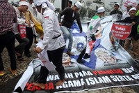 Massa menginjak-injak spanduk yang mereka bawa.