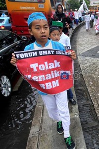 Seorang anak kecil membawa spanduk kecil bertuliskan Tolak Kenaikan Harga BBM yang rencananya akan dinaikkan oleh pemerintah pada 1 April mendatang.