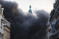 Asap hitam membumbung tinggi di dekat patung Napoleon. AFP.