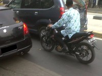 Pagi hari di saat kawasan Mampang macet total, tiba-tiba ada pria berpeci berbatik PNS bebas melenggang.