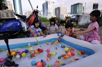 Anak-anak asyik bermain pancingan yang terbuat dari bahan plastik di Kawasan Setiabudi, Jakarta, Jumat (9/3/2012).