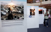 Seorang pengunjung melihat foto yang dipamerkan.