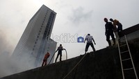 Petugas pemadam berusaha menjinakkan api.