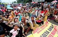 Para guru honorer yang mengenakan pakaian dinas berwarna cokelat dan hijau meneriakkan yel-yel tuntutan.
