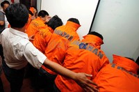Para pelaku perampokan menutupi wajahnya dengan baju tahanan yang mereka kenakan.