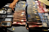 Selain uang dan senjata api, polisi juga mengamankan sejumlah handphone.