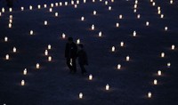 2 anak laki-laki berjalan diantara cahaya lilin untuk mengenang korban gempa bumi.REUTERS/Kim Kyung-Hoon