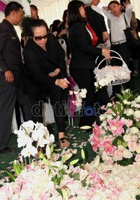 Dengan raut wajah sedih Oma Olivia menaburkan bunga mawar putih di atas pusara.