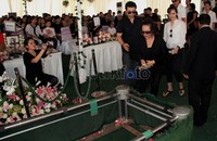 Oma Olivia menaruh tanah di makam anaknya.