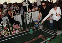 Natalie dan sang suami nampak sedih menaruh tanah di makam Olivia.