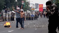 Polisi akhirnya membubarkan demonstran dengan menembakan gas air mata.