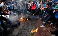 Polisi berusaha mencegah dan memadamkan aksi bakar tersebut.