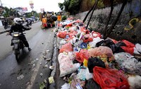Di saat petugas kebersihan mengangkut sampah yang menumpuk, terlihat seorang pengendara sengaja membuang sampah di lokasi tersebut.