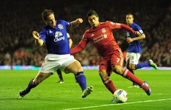 Luis Suarez meliuk-liuk untuk melewati Phil Jagielka. Getty Images/Jamie McDonald.