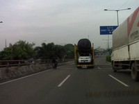Sambil berboncengan pengendara motor masuk jalan tol Tanjung Priok.