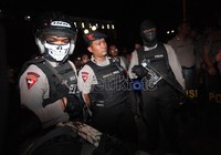 Polisi ini menggunakan penutup wajah dan senjata laras panjang lengkap dengan amunisinya. Belum dikonfirmasi apakah berisi peluru karet ataukah  peluru tajam.
