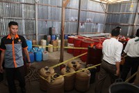 Sejumlah petugas kepolisian berdiri di sebelah barang bukti berupa puluhan jerigen berisi Bahan Bakar Minyak (BBM) saat melakukan penggebrekan di sebuah gudang di Jalan Adisucipto, Kabupaten Kubu Raya, Kamis (15/3). ANTARA/Sheravim.
