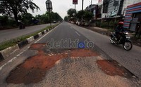 Jalan yang rusak hanya ditimbun dengan tanah merah.