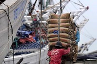 Dua orang pekerja menurunkan puluhan sak semen dari kapal di Kawasan Sunda Kelapa, Jakarta.