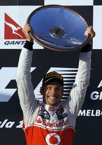 Jenson Button mengangkat trofi kemenangan di atas podium. Reuters/Daniel Munoz