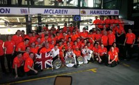 Seluruh awak McLaren beserta dua pembalapnya, Jenson Button serta Lewis Hamilton, merayakan kemenangan di depan paddock.
