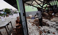 Warga membersihkan puing-puing bangunan sekolah yang ambruk.